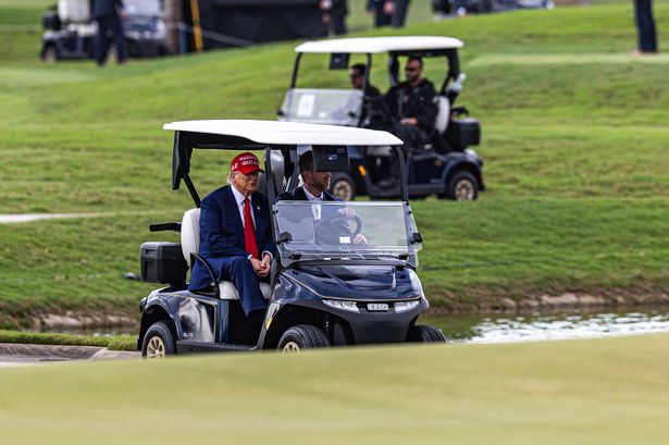 DORAL, FLORIDA - APRIL 03: U.S. President Donald Trump and his son Eric Trump drive in a golf cart after arriving on Marine One on the ninth hole during previews for LIV Golf Miami at Trump National Doral Miami on April 03, 2025 in Doral, Florida. (Photo by Lauren Sopourn/Getty Images)