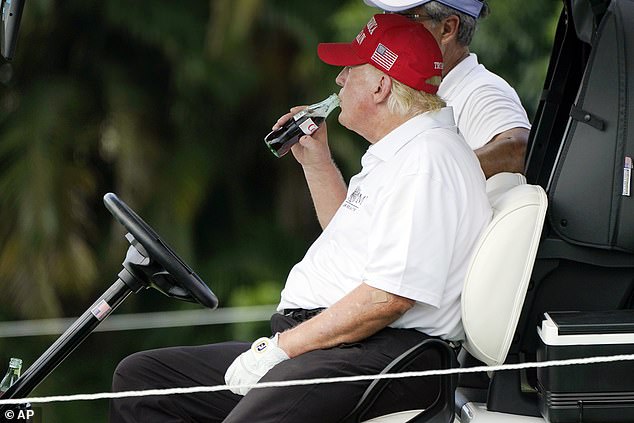 The president is pictured sipping from a bottle of Diet Coke during a round of golf in 2022