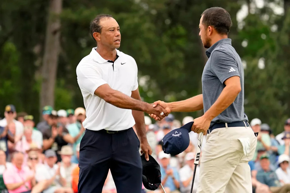 Tiger Woods (left) shakes hands with Xander Schauffele after finishing the first round of the Masters.