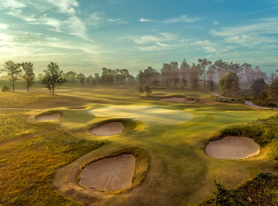Early morning fog envelopes The Loop at the par-3 6th green of The Red Course/par-4 12th green of The Black Course at Tom Doak's reversible design at Forest Dunes in Roscommon.