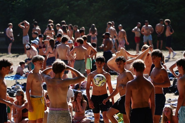 epa12209041 People play ball at the Eisbach creek at the English Garden in Munich, Germany, 01 July 2025. The German Weather Service is warning of a heat wave with temperatures reaching up to 38 degrees Celsius across much of the country. EPA/ANNA SZILAGYI