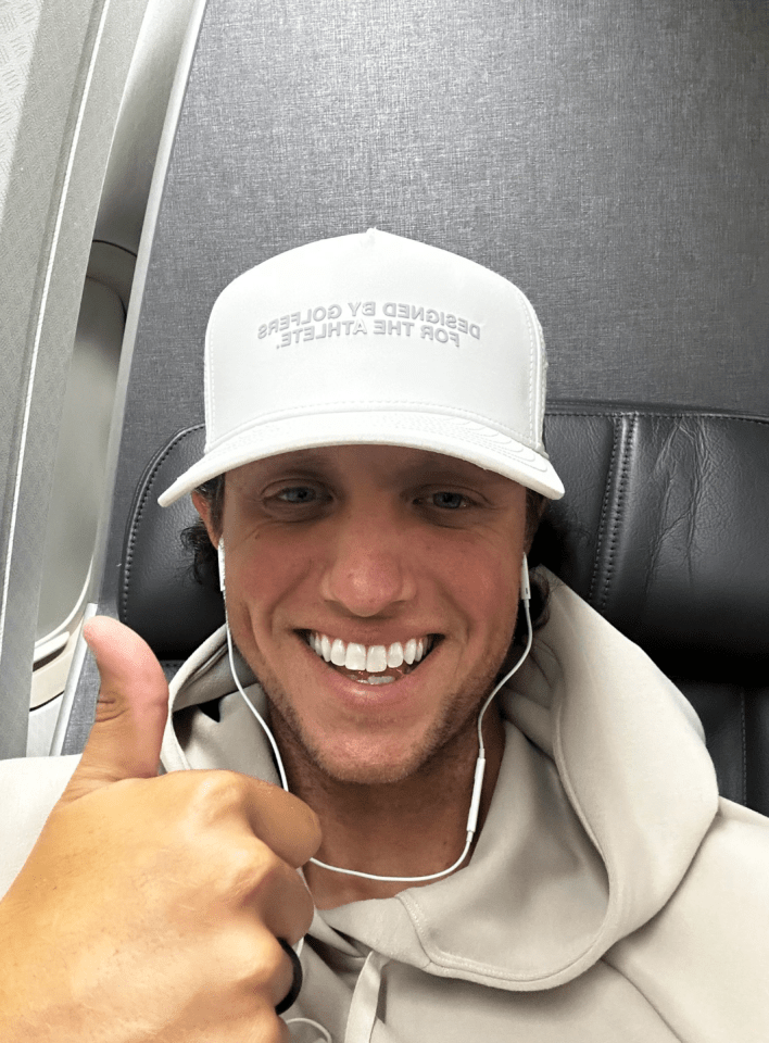 Man wearing a white hat giving a thumbs up.
