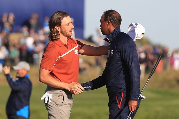 Team Europe's Tommy Fleetwood shakes hands with Team USA's Tiger Woods after victory on the 14th during the Foursomes match on day two of the Ryder Cup at Le Golf National, Saint-Quentin-en-Yvelines, Paris