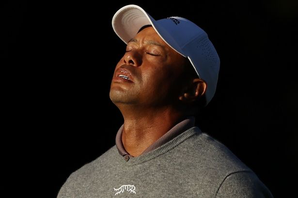 Tiger Woods reacts to playing a shot