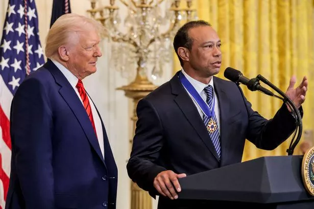 Donald Trump watches on as Tiger Woods addresses the crowd