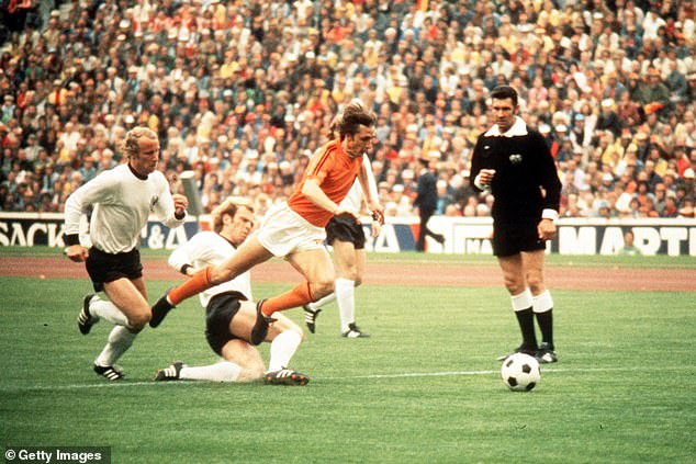 Pictured: Johan Cruyff jumps over a tackle from Hoeness during the 1974 World Cup final