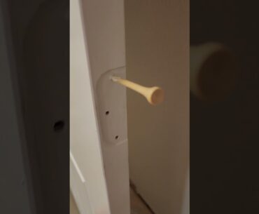 Fixing a door with golf tees.