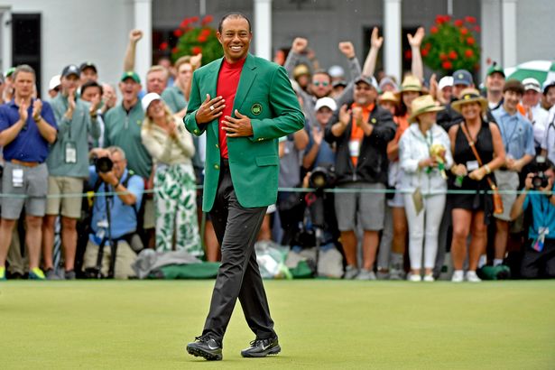 Masters champion Tiger Woods walks on No. 18 green after he was presented with his Green Jacket in 2019
