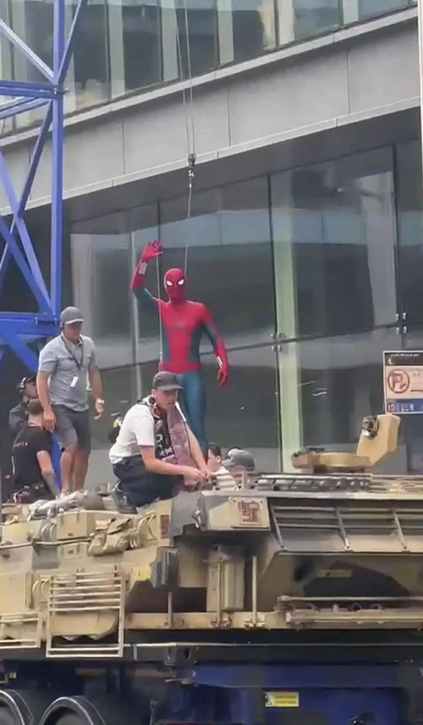 Tom Holland giving fans a wave during filming on Bothwell Street
