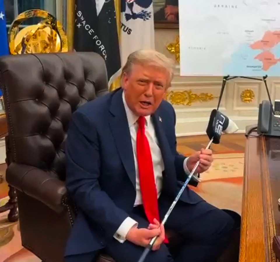 President Trump holding a golf club presented to him by President Zelensky.