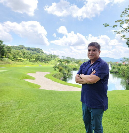 Kim Han-ryong, CEO of The Cross BGC, poses against the backdrop of the course.