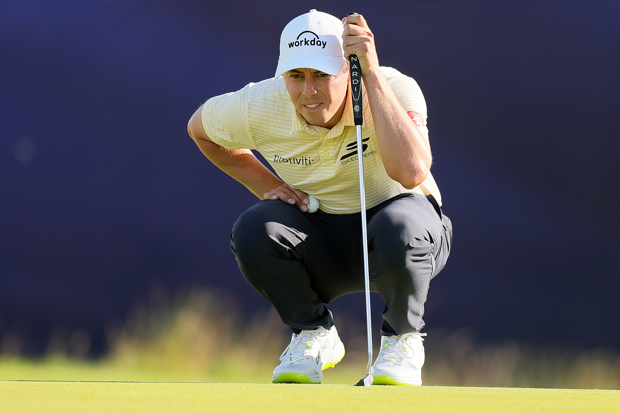 Matt Fitzpatrick, Bazza's best top-10 finish bet at the BMW Championship, crouching down behind the golf ball on the green with his putter reading the line of the putt
