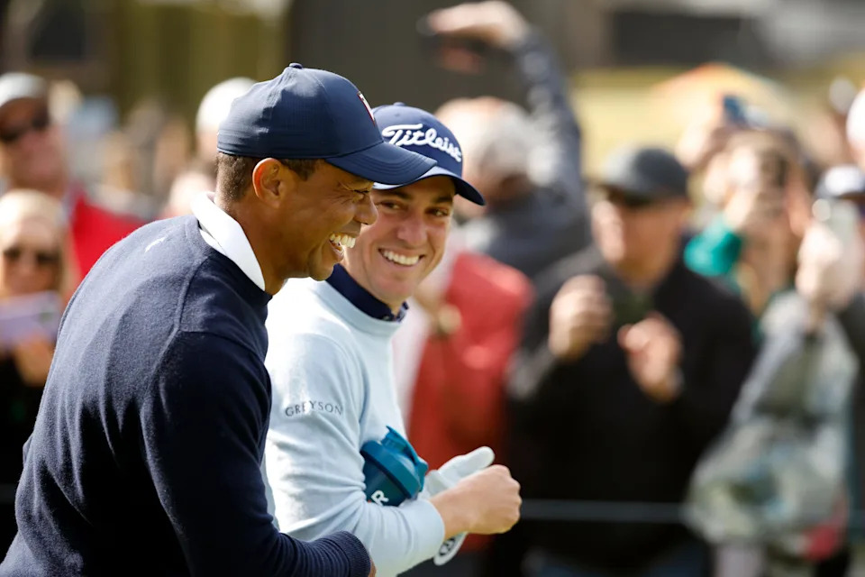 Tiger Woods of the United States and Justin Thomas of the United States walk across the ninth hole during the first round of the The Genesis Invitational at Riviera Country Club on February 16, 2023 in Pacific Palisades, California.