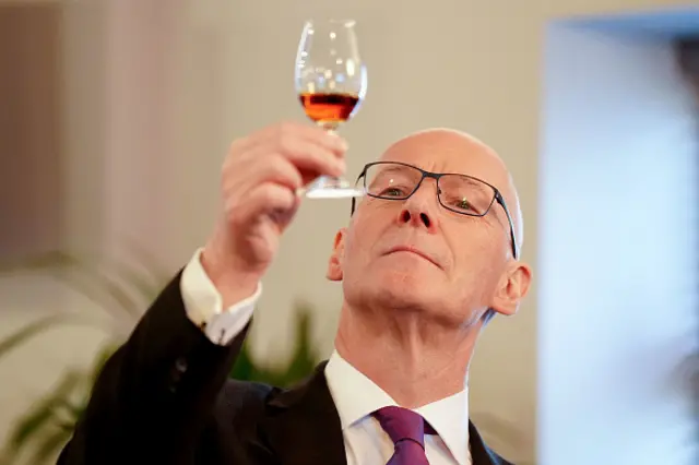 John Swinney looks at a glass of whisky