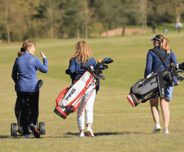 Three female golfers walking