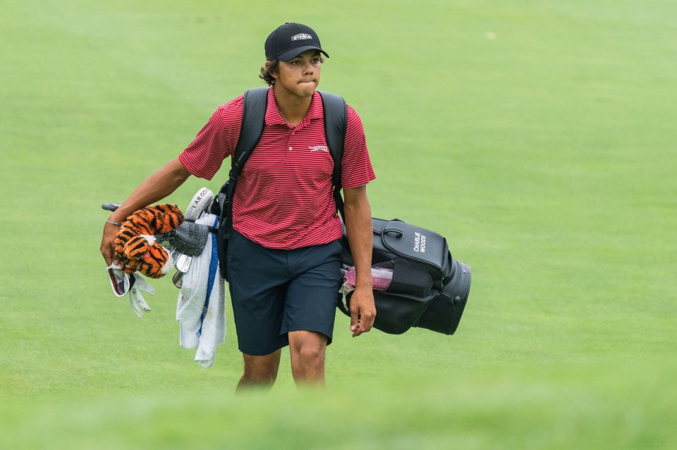 Charlie Woods walking on a golf course, carrying his golf bag.