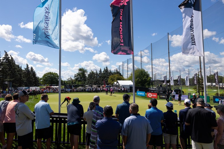 Fans circle around a practice putting green.