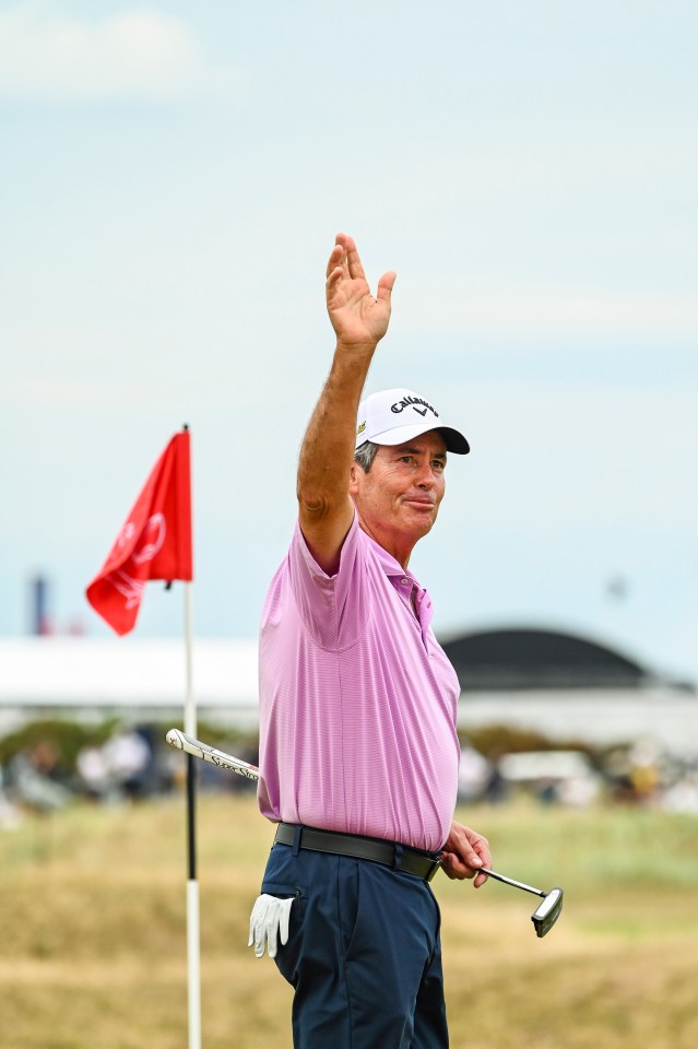 Ian Baker-Finch waving to fans at a golf tournament.
