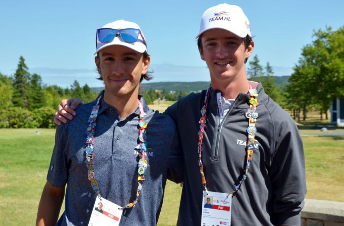 Two boys standing near a golf course.