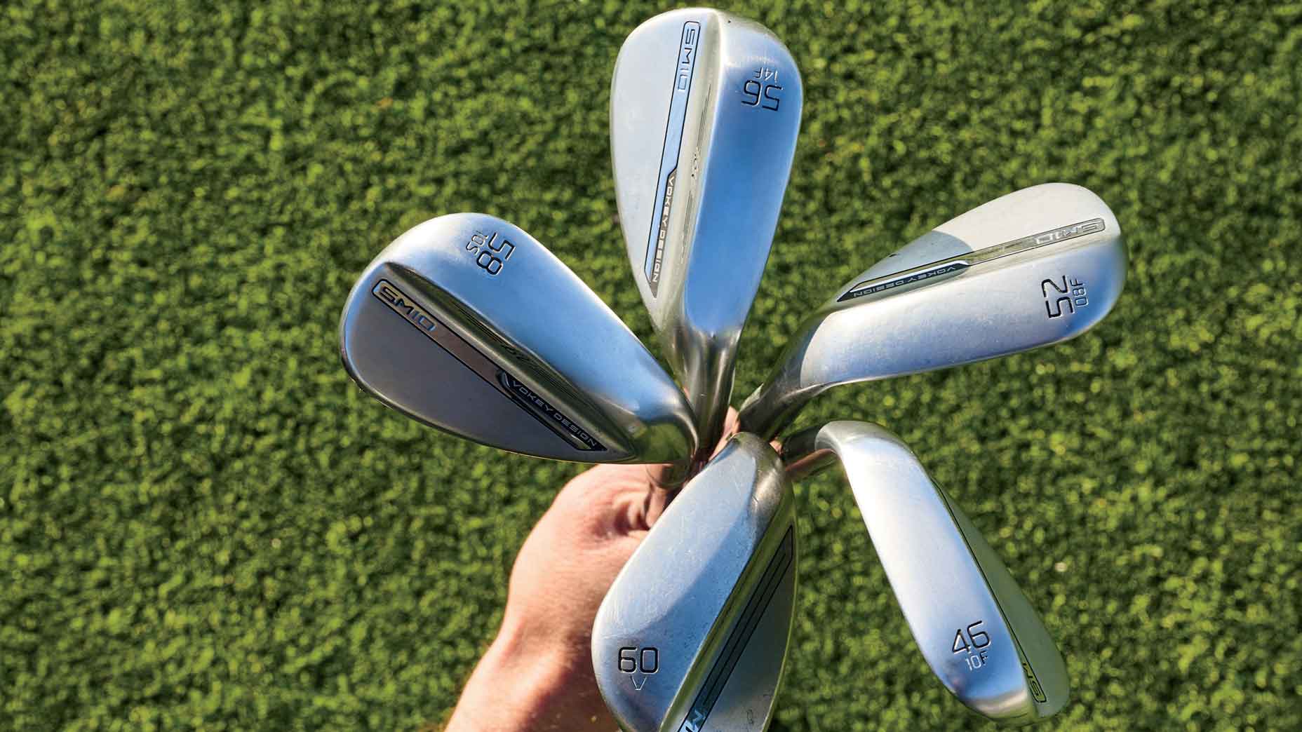 Hand holding five wedges of different lofts