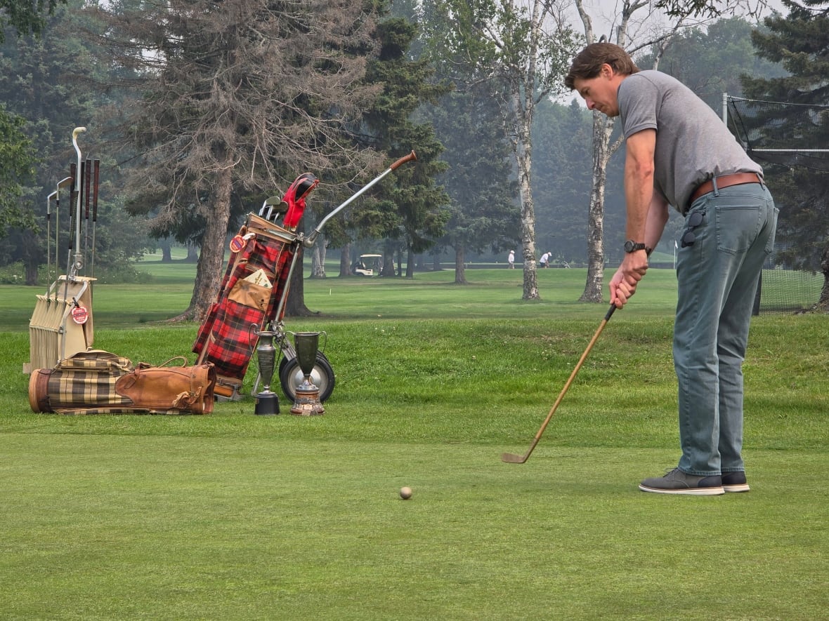 A man putts on a putting green.