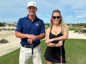 Bryson Dechambeau and Paige Spiranac pose on a golf course.