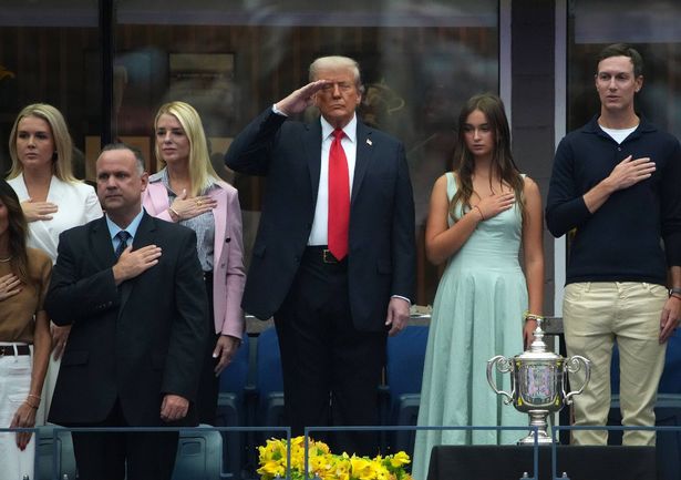 Donald Trump salutes while attending the US Open