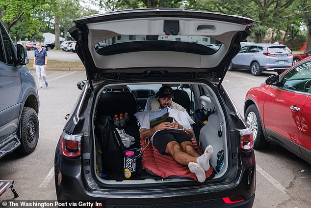 A golfer sets up camp in his trunk as he waits for his chance to take on the Ryder Cup course