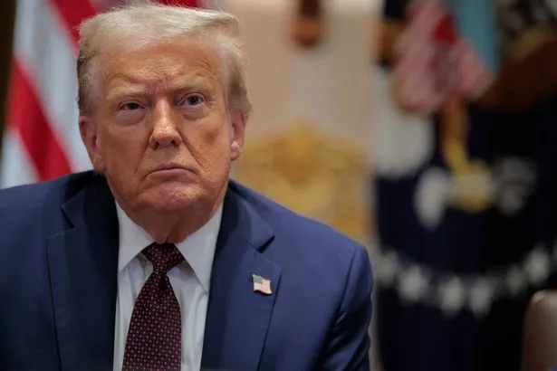 Donald Trump looks on while wearing a suit