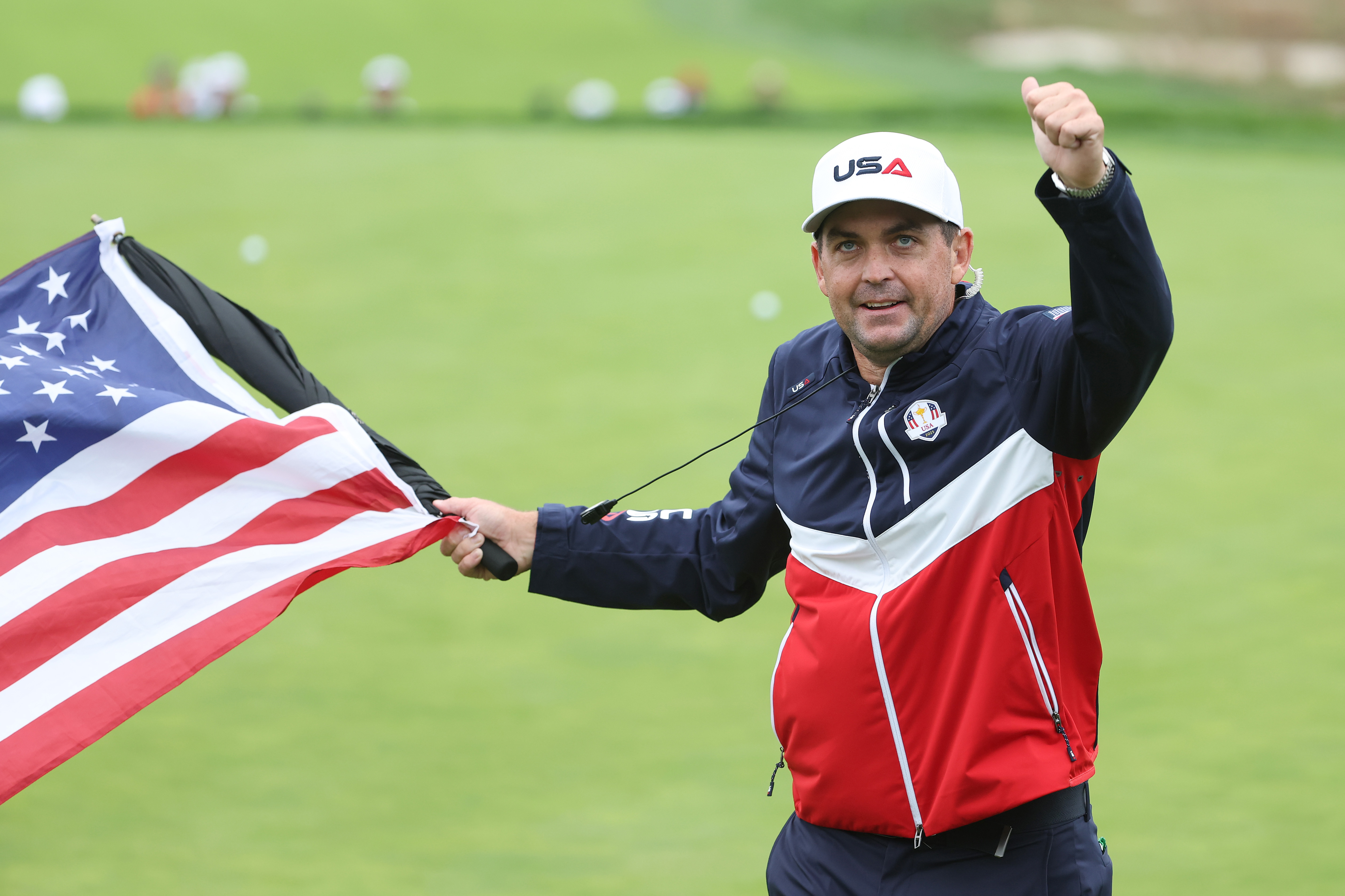 Keegan Bradley holds the US flag and thumbs up