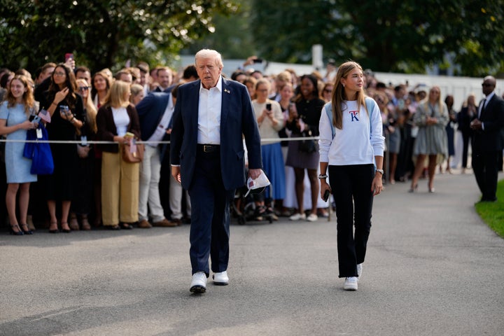 President Donald Trump walks with granddaughter Kai Trump on the South Lawn of the White House before boarding Marine One.