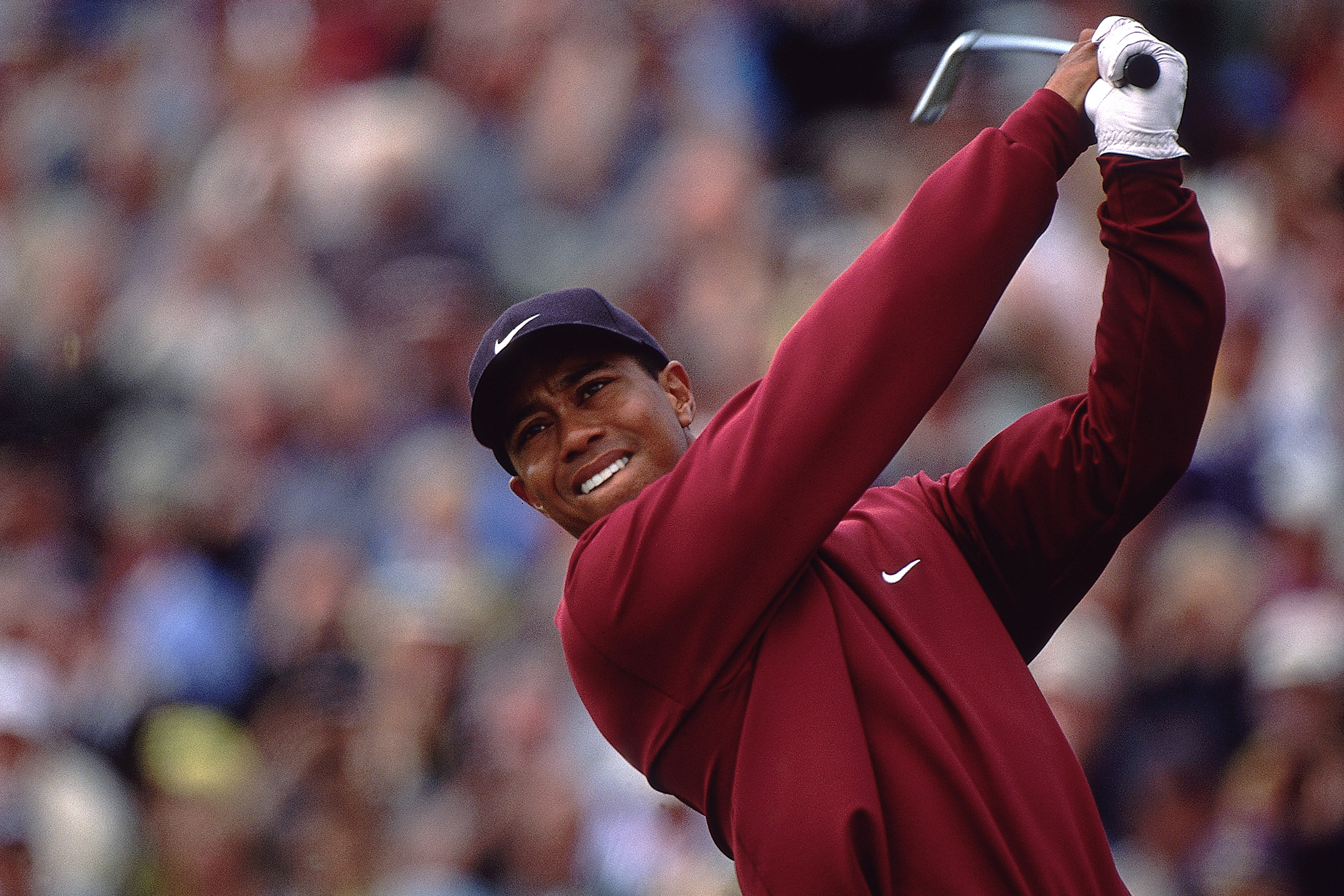 Tiger Woods wearing his iconic Sunday red nike clothing in the finish position with an iron