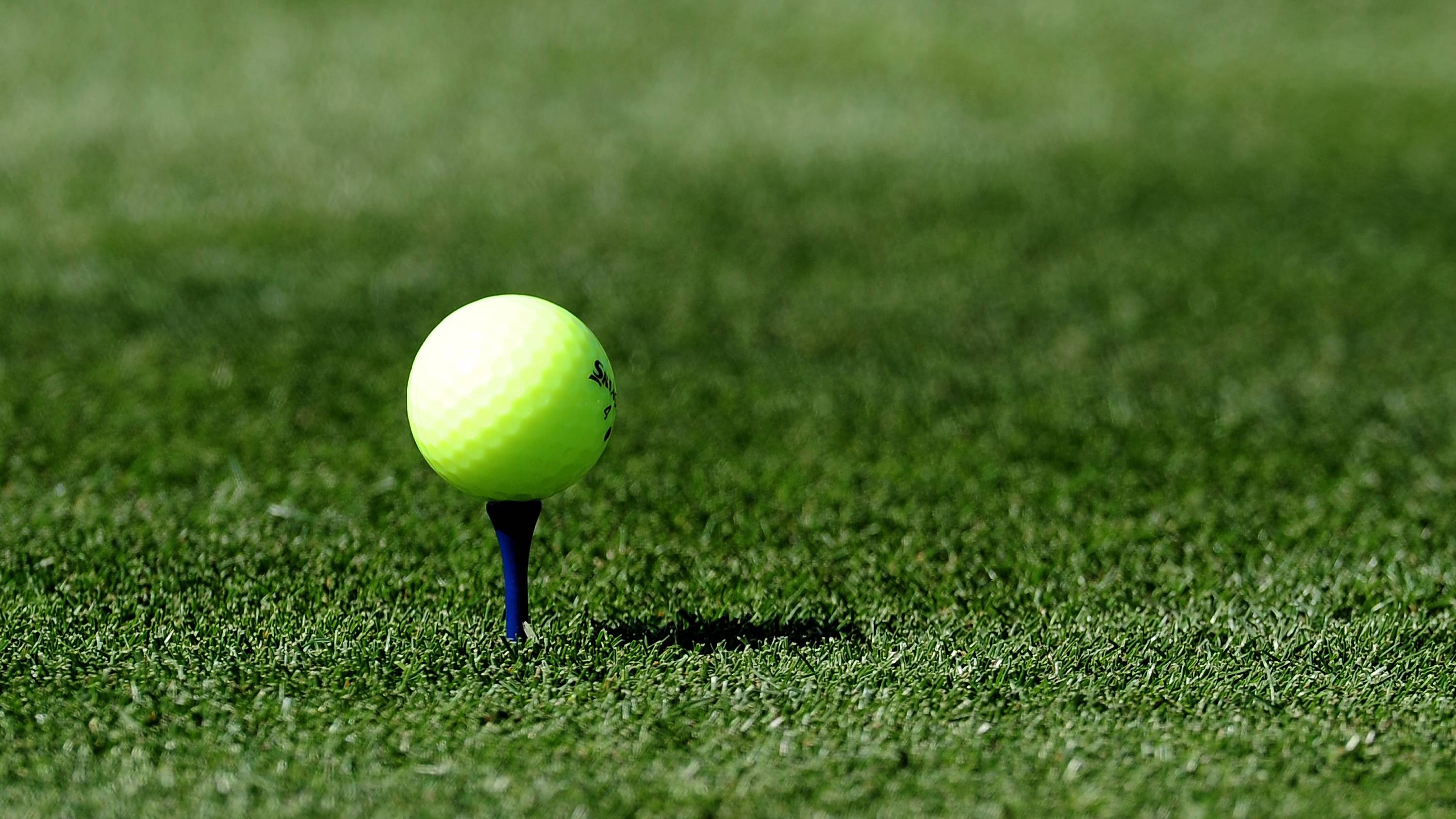 Yellow golf ball on tee
