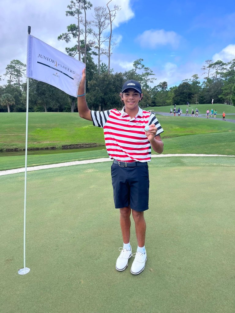 Charlie Woods poses with his hole-in-one ball. 