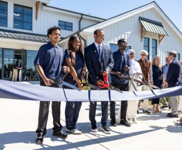 Tiger Woods poses with some TGR Learning Lab students at the grand opening of the Cobbs Creek center that his foundation helped fund.