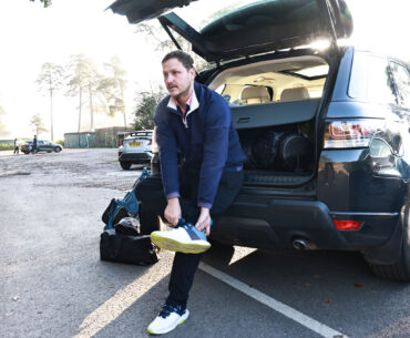 Golfer changing shoes in car park