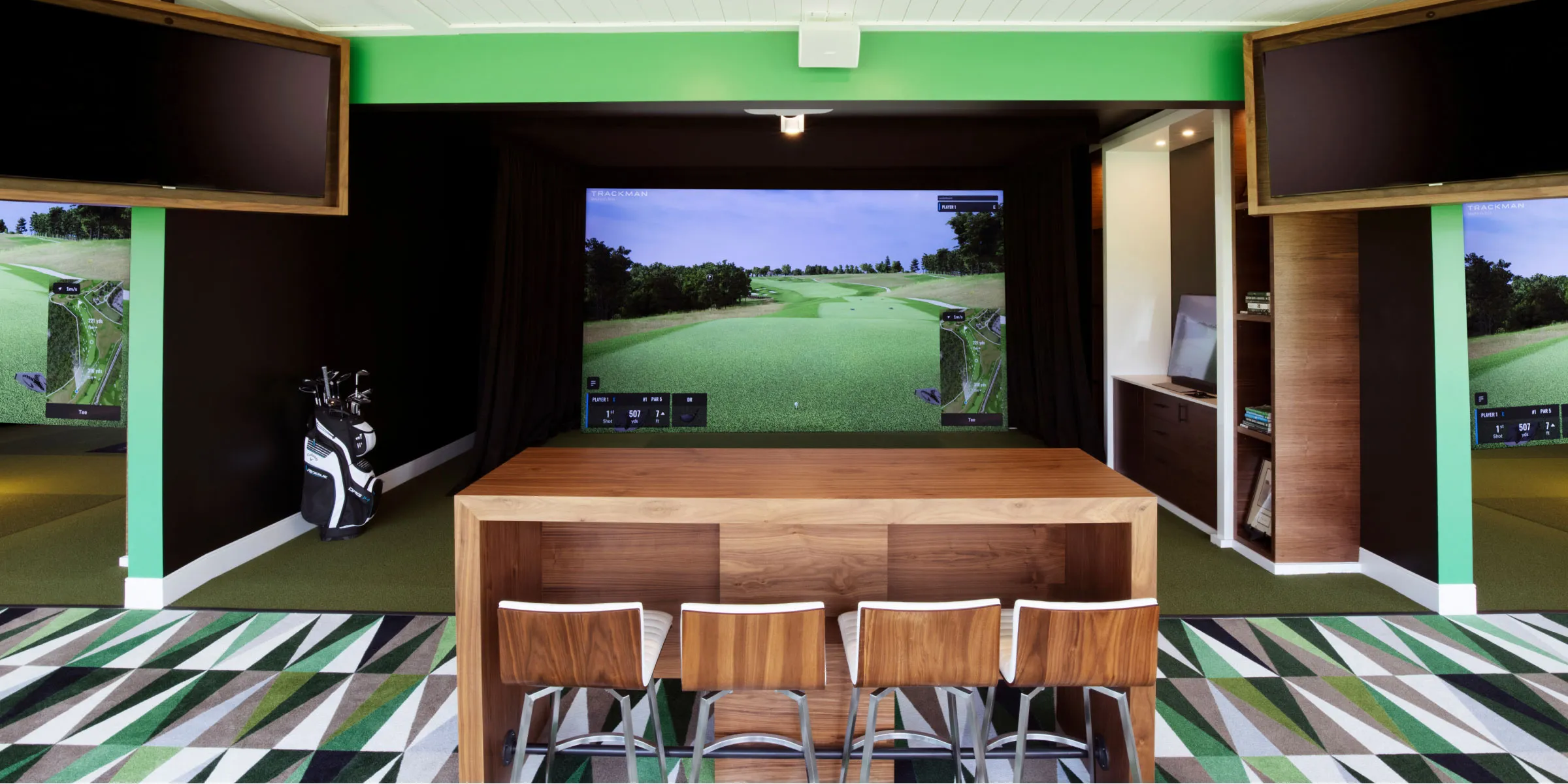 A golf "classroom" at Nemacolin Golf Academy, showing a desk with four chairs facing a simulator. From: https://www.nemacolin.com/golf/golf-academy/