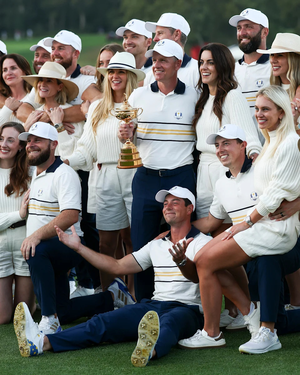 Captain Luke Donald holds the Ryder Cup trophy alongside Shane Lowry, Rasmus Hojgaard, Justin Rose, Jon Rahm, Sepp Straka, Ludvig Aberg, Rory McIlroy, Viktor Hovland, Matt Fitzpatrick, Tommy Fleetwood, Robert MacIntyre and Tyrrell Hatton of Team Europe and their wives and girlfriends after their 15-13 win over Team United States during the Sunday singles matches of the 2025 Ryder Cup at Black Course at Bethpage State Park Golf Course on September 28, 2025 in Farmingdale, New York. (Photo by Jared C. Tilton/Getty Images)