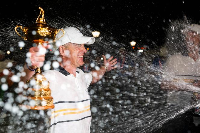 Captain Luke Donald of Team Europe holds the Ryder Cup trophy as he is doused with champagne after winning the 2025 Ryder Cup at Black Course at Bethpage State Park Golf Course in Farmingdale, New York on September 28, 2025.  