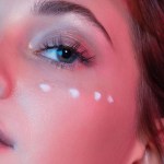 Woman using eye cream, like THESAEM's Iceland Hydrating Peptide Eye Stick