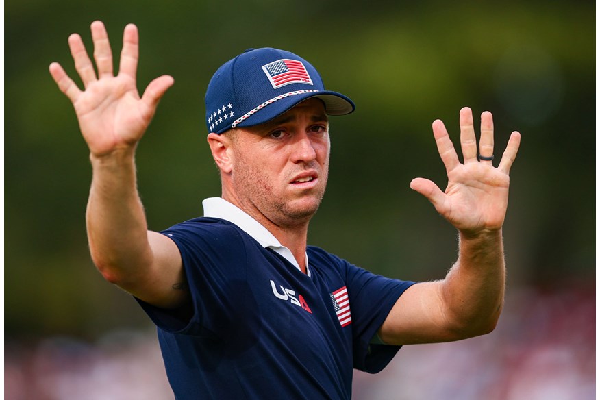 Justin Thomas tries to calm the crowds during his and Cameron Young's match with Rory McIlroy and Shane Lowry.