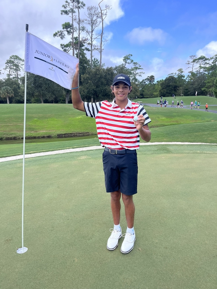 Charlie Woods taking a commemorative photo after scoring a hole-in-one in the Junior Players Championship. AJGA