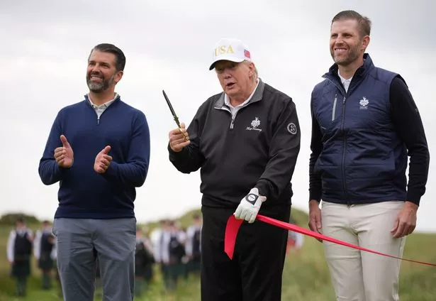 U.S. President Donald Trump speaks next to Donald Trump Jr.  and Eric Trump