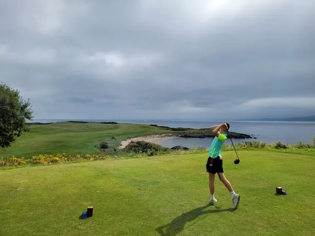 A young golfer tees off at Greencastle Golf Club in Co Donegal, overlooking Lough Foyle