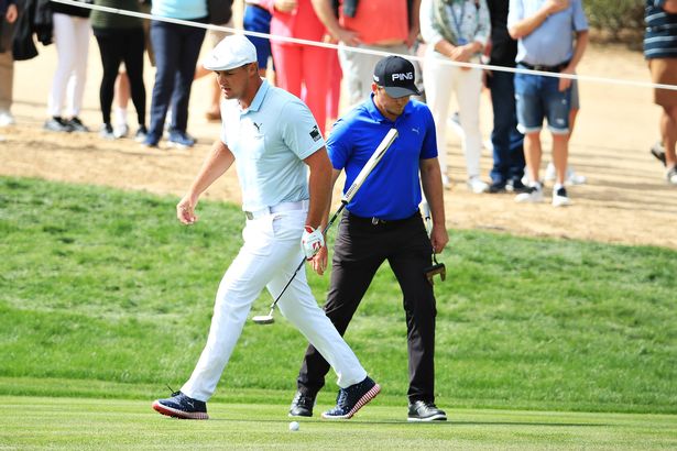 Eddie Pepperell of England and Bryson Dechambeau of United States look on from the second hole during Day Four of the Omega Dubai Desert Classic