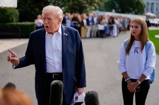 US President Donald Trump, left, and granddaughter Kai Trump, daughter of Donald Trump Jr., on the South Lawn of the White House before boarding Marine One in Washington, DC, US, on Friday, Sept. 26, 2025. Trump's plan to impose a 100% tariff on branded drug imports was greeted with a shrug by many investors, who are betting his exemptions for companies with US manufacturing will soften any blow. Photographer: Kent Nishimura/Bloomberg via Getty Images