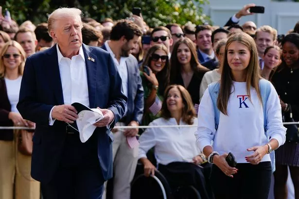 Kai Trump watches as her grandfather President Donald Trump speaks to reporters before departing the White House, Friday, Sept. 26, 2025, in Washington. (AP Photo/Julia Demaree Nikhinson)