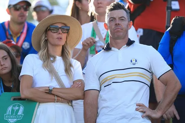 Rory McIlroy of Europe looks on with his wife Erica by the 17th green during the Sunday singles matches of the 2025 Ryder Cup