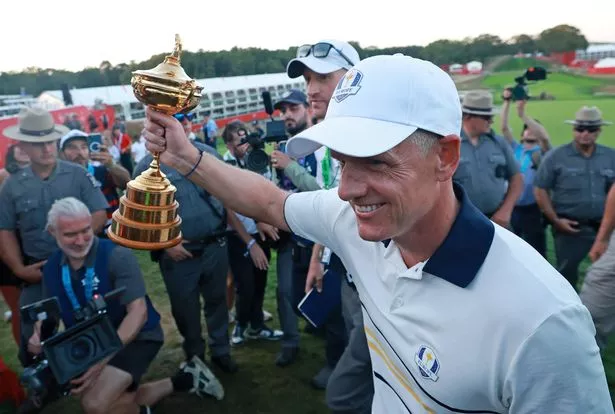 FARMINGDALE, NEW YORK - SEPTEMBER 28: Captain Luke Donald of Team Europe walks off the course with the Ryder Cup trophy after Team Europe defeated Team United States 15-13 during the Sunday singles matches of the 2025 Ryder Cup at Black Course at Bethpage State Park Golf Course on September 28, 2025 in Farmingdale, New York. (Photo by Carl Recine/Getty Images)