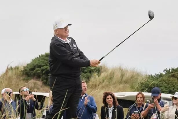 United States President Donald Trump tees off during the opening ceremony for the Trump International Golf Links golf course